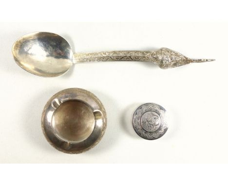 Thai white metal metal ladle with a figure and foliate decorated handle, L.31.8cm; white metal circular box, Dia.5.8cm, and a