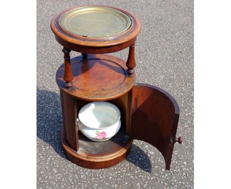 Victorian cylindrical mahogany washstand with a later loose brass top, on cylindrical columns with an undertier and panel doo