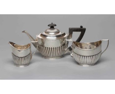 AN EDWARDIAN SILVER THREE PIECE TEA SERVICE, by Mappin &amp; Webb, Sheffield 1903, of semi-fluted oval form comprising teapot
