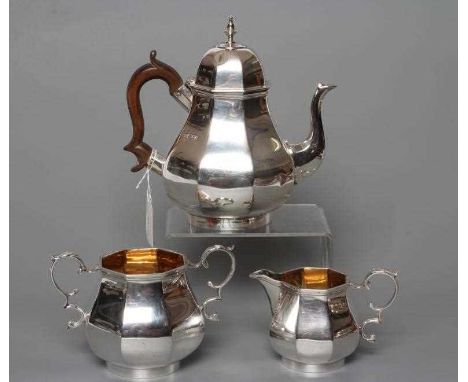 AN EDWARDIAN SILVER THREE PIECE TEA SERVICE, by Goldsmiths &amp; Silversmiths Co. Ltd., London 1910, of octagonal baluster fo