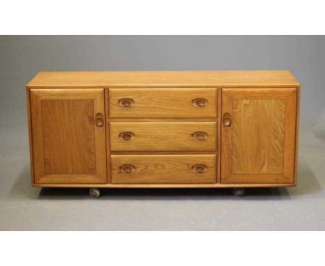 AN ERCOL LIGHT ELM SIDEBOARD, mid/late 20th century, comprising three central drawers with oval wood handles flanked on eithe