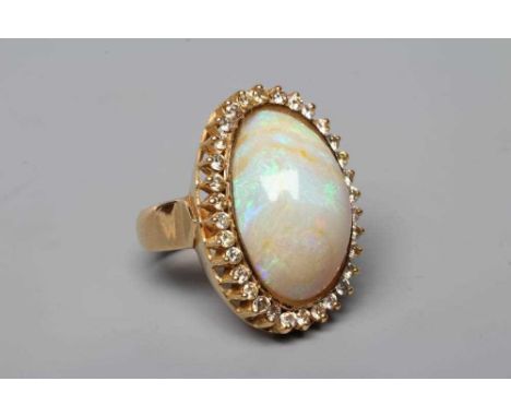 AN OPAL DRESS RING, the oval cabochon polished stone collet set to a border of numerous small brilliant cut diamonds on a pla