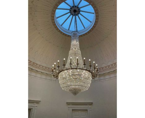 AN IMPRESSIVE GILT METAL AND CUT GLASS TWENTY-FOUR FLAME CHANDELIER, 20th century, of tent form with crystal drops, the scrol