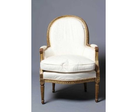 A LOUIS XV STYLE CARVED GILTWOOD FAUTEUIL, late 19th century, upholstered in a white stylised floral weave, the arched back w