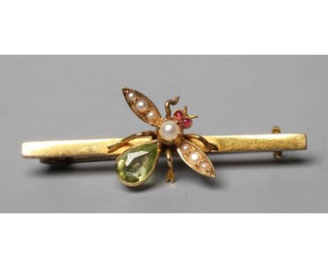AN EDWARDIAN NOVELTY BAR BROOCH centred by an insect with seed pearl wings and head, ruby cabochon eyes and peridot body, unm