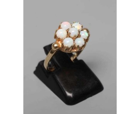 A SEVEN STONE OPAL RING, the circular cabochon polished stones claw set to a plain 9ct gold shank, London 1964, size L (Est. 