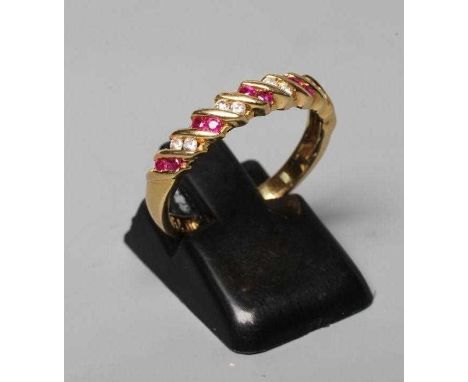 A RUBY AND DIAMOND HALF HOOP RING, the five pairs of rubies and four pairs of small brilliants channel set in a twist mount t