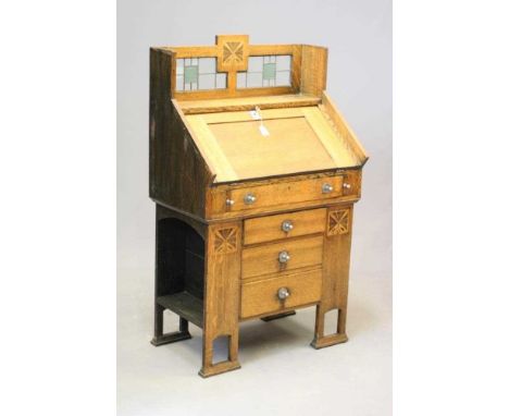 AN ARTS AND CRAFTS OAK BUREAU, late 19th century, inlaid with stylised foliate panels, the raised back with stained and leade
