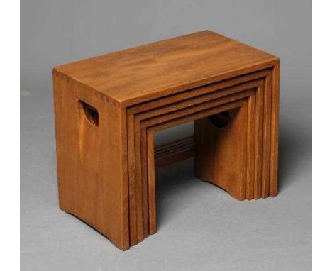 AN ERCOL LIGHT ELM NEST OF FIVE TABLES of oblong form, the solid sides pierced with inset loop handles and joined by a square