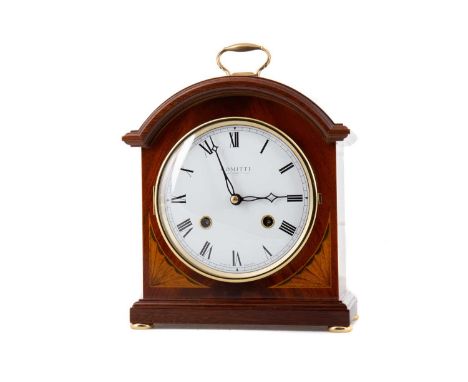COMITTI OF LONDON, MANTEL CLOCK CONTEMPORARY in the Edwardian style, with brass handle to the arched top over a white enamel 