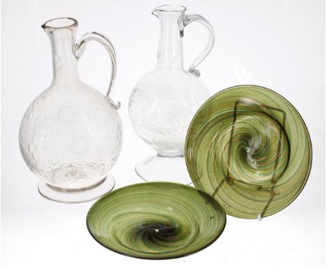 Two similar glass wine decanters, the first with etched foliate decoration raised on a wide foot rim, the second with moulded