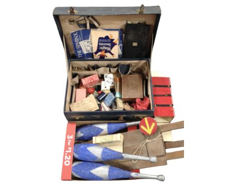 A vintage suitcase and further box containing magician's items, including playing cards, juggling batons, and other items.