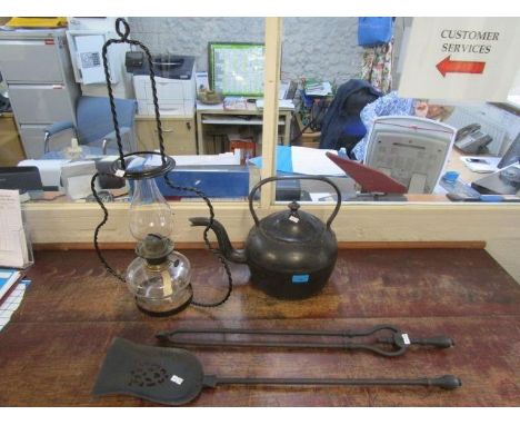 A large cast iron kettle, a cast iron fire shovel and coal grabbers and a glass oil lamp with wrought iron hanging frame 