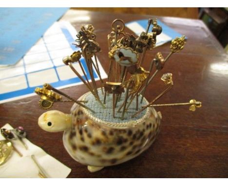 A mixed lot to include a model of a tortoise, a hen stick pin cushion with various stick pins, a pair of cuff links and a com