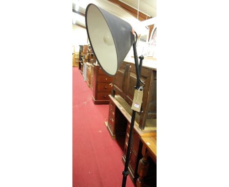 A black painted wrought iron standard lamp, having adjustable shade