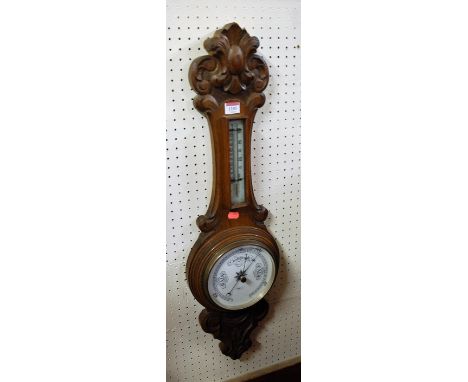 A 1930s carved oak aneroid two dial wheel barometer