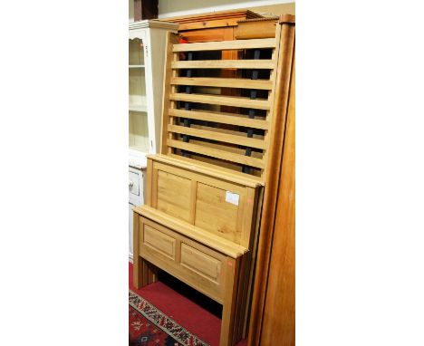 A pair of contemporary light oak single bedsteads, each having fixed slatted base sections