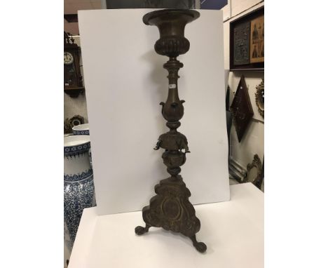 A 19th Century brass pricket candlestick with foliate and cross decoration raised on claw and ball feet 74cm high