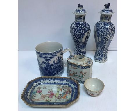 A similar pair of 19th Century Chinese blue and white hexagonal baluster vases and covers decorated with figures in garden se