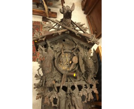 A late 19th Century Black Forest cuckoo clock of large proportions, the case decorated with stag's head and crossed rifles, o