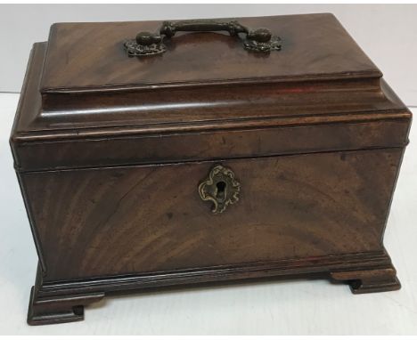 A George III mahogany tea caddy with brass handle, the top opening to reveal a three section interior (no lids) raised on oge