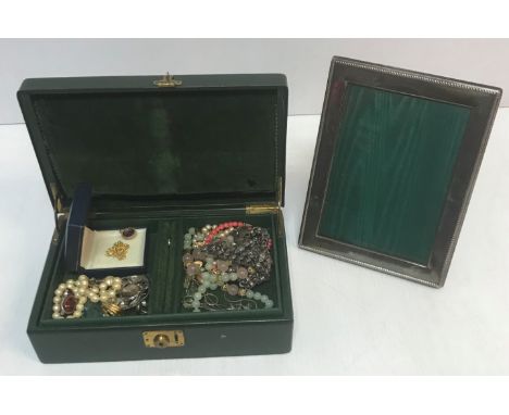 A green leather jewellery box containing various costume jewellery to include a jade beaded necklace with carved stylised Chi