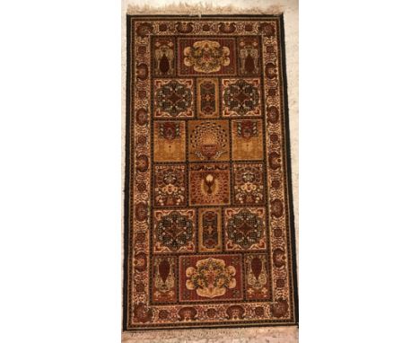 A Persian style rug, the central panel set with floral decorated tile motifs on a dark brown ground, within a stepped cream, 