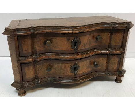 An 18th Century walnut miniature serpentine fronted commode/chest, the cross banded and inlaid top with moulded edge over two