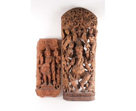 An Indian teak wood arched architectural panel, carved and pierced with Lord Ganesh and attendants in relief upon a double lo