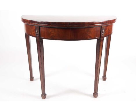 A George III rosewood crossbanded mahogany demi lune fold over card table with paterae carved and moulded supports terminatin