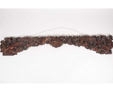 A 19th century, South European carved and pierced limewood architectural mantle with scrolls and winged putto. 180 cm long x 
