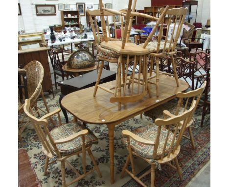 A modern stained wood and beech kitchen table and six stick-back beech chairs.