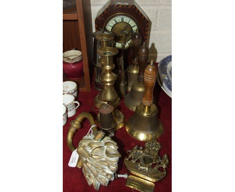 A brass door knocker in the form of a lion's mask, 22cm, a pair of brass candlesticks, three turned-wood-handled brass hand b