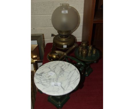 A set of weighing scales with ceramic plate and brass weights, a brass oil lamp, a pestle and mortar and other metalware.