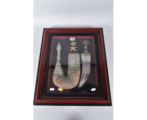 A WOODEN GLAZED BOX STYLE FRAME MEASURING APPROX 50 x 42 cm, containing an ornate Arab Jambiya Dagger and scabbard. The grip 