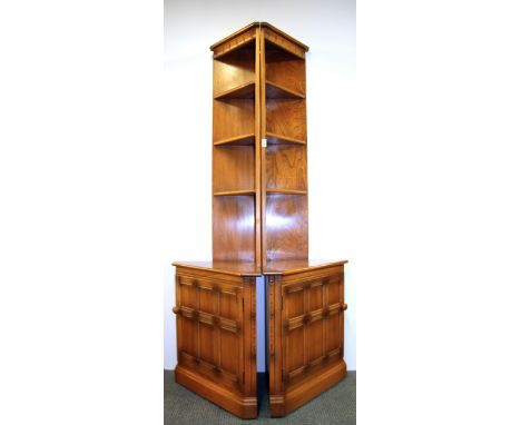 A pair of light oak Ercol corner cabinets.