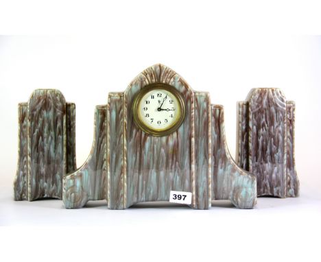 An Art Deco three piece ceramic clock set, clock H. 26cm.