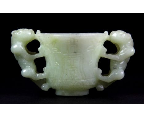 A small two handled Chinese carved nephrite jade wine cup, W.9cms H.5cms.