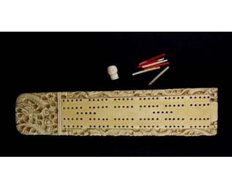 A 19th century Chinese carved ivory cribbage score board, L.19cms with ivory pegs.