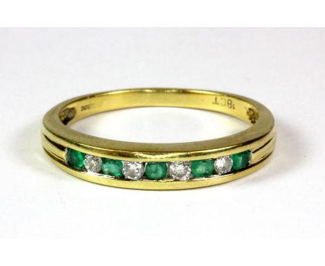 An 18ct yellow gold (stamped 18ct) emerald and diamond half eternity ring, (R).