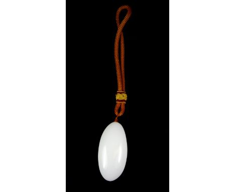 A Chinese white jade/hardstone pebble amulet with silk carrying cord, L.8cms.