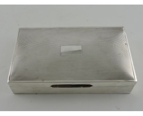 A rectangular silver cigarette box, Birmingham 1956, with an engine turned lid incorporating a vacant cartouche, W. 15cm