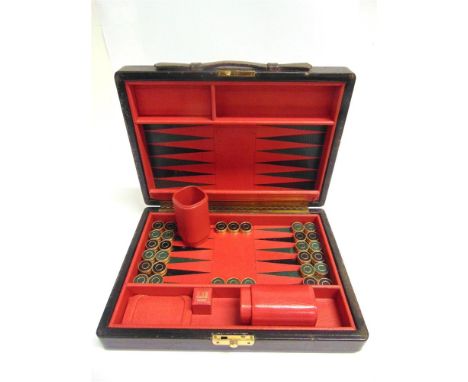 A DUNHILL BACKGAMMON SET  the black leather case opening to reveal a red, black and green leather fitted interior, with magne