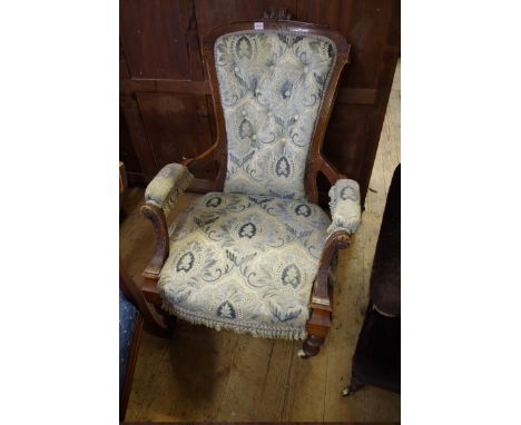 A Victorian carved walnut and button upholstered open arm occasional chair.&nbsp; 