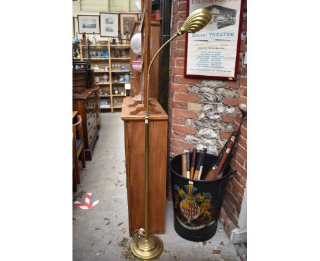 A brass adjustable standard lamp, with articulated neck and brass shell shade. 