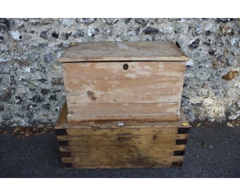 A stripped pine trunk, having iron loop handles, 91cm wide x 40cm high, together with a smaller pine trunk, 77cm wide x 46cm 