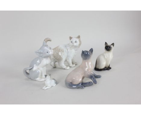 A Royal Copenhagen porcelain model of a cat, 10.5cm high, together with four various porcelain models of cats; Lladro, Royal 