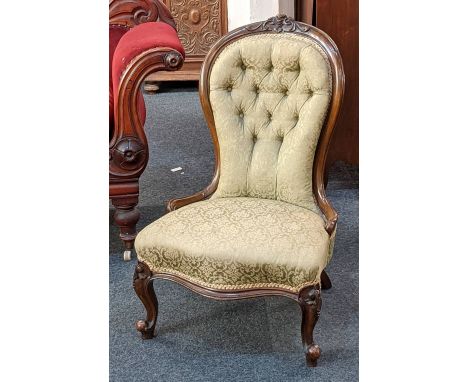 A Victorian button upholstered chair with carved balloon back on cabriole legs 