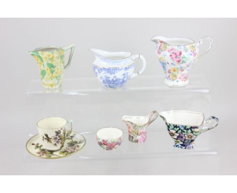 A Doulton Lambeth Faience coffee cup and saucer, decorated with blossom on pale yellow ground and a Royal Crown Derby blue an
