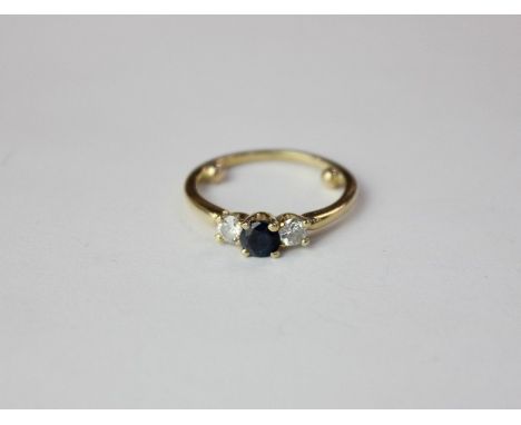 A three stone ring with sapphire and two white stones in 18ct yellow gold